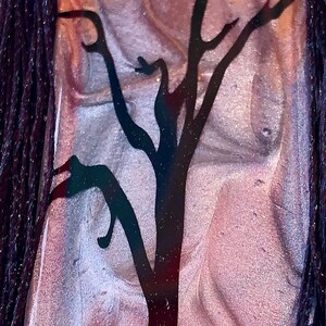 May include: A brown and silver resin bookmark with a black silhouette of a tree and a skull with crossbones. The bookmark has a black tassel.