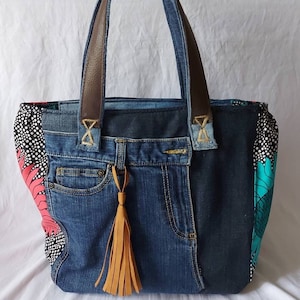 Women's handbag made from recycled denim, colorful floral wax print on the sides, zipper closure