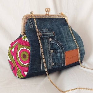 May include: A denim handbag with a gold chain strap and a pink and green floral fabric lining. The bag has a clasp closure and a brown leather patch with the text "OBAMS BAGS".