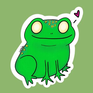 May include: A green frog with yellow stars on its back and large, white eyes. The frog is smiling and has a pink heart above its head.