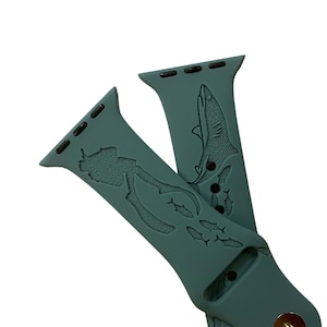 Op de afbeelding: Tealblauwe Apple Watch band met een duiker- en visontwerp. De band heeft een haai-ontwerp aan de andere kant.