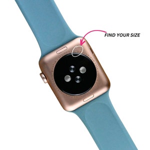 Puede incluir: Un Apple Watch Series 3 de color oro rosa con una banda deportiva azul. La parte posterior del reloj es visible, mostrando el texto "Apple Watch Series 3 42MM Aluminum Case".