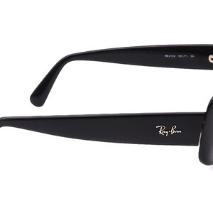 May include: Black Ray-Ban sunglasses with a square frame and thick black arms. The sunglasses have a silver Ray-Ban logo on the right arm.