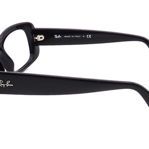 May include: Black Ray-Ban eyeglasses with a rectangular frame and black arms. The arms are marked "Ray-Ban" and "Made in Italy K CE".