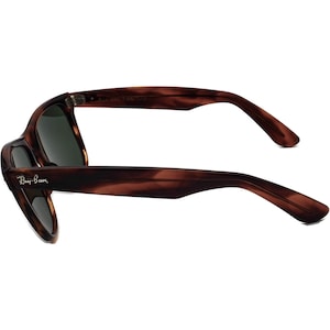 Może przedstawiać: Okulary przeciwsłoneczne Ray-Ban w brązowym kolorze imitującym pancerzyk ż&oacute;łwia z zielonymi szkłami. Okulary mają klasyczny kwadratowy kształt i są wykonane z tworzywa sztucznego.