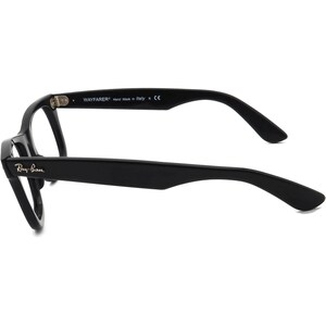 May include: Black Ray-Ban Wayfarer eyeglasses with a classic design. The frame is made of plastic and has a black finish. The arms are black and have the Ray-Ban logo and "WAYFARER" text.