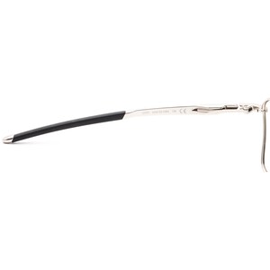 May include: Silver-toned metal eyeglasses with black temple tips. The frame has a unique design with a slight curve. The text "CARINE CD4134-E862 138 CE" is printed on the frame.