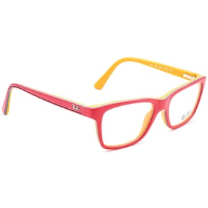 Puede incluir: Gafas rectangulares rojas, amarillas y azules con lentes transparentes. El nombre de la marca "Ray-Ban" está impreso en el lateral de la montura.