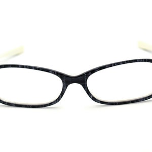 May include: Black and white patterned eyeglasses with a white frame.