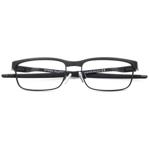 K&ouml;nnte beinhalten: Schwarze Metallgestellbrille mit klaren Gl&auml;sern. Der Rahmen hat eine subtile Kr&uuml;mmung und die B&uuml;gel sind aus Metall. Der Text "STEEL PLATE" und "Y3002-0148 Satin Black CE" ist auf dem Rahmen aufgedruckt.