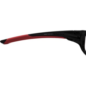May include: Black and red sports sunglasses with the word "VALVE" printed on the side. The sunglasses have a red rubber temple arm and the text "DC2042 60 16 130" printed on the arm.