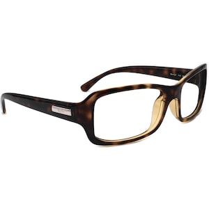 Puede incluir: Gafas de pasta de carey con montura rectangular y lentes transparentes. Las gafas tienen un logotipo Ray-Ban plateado en el lateral.