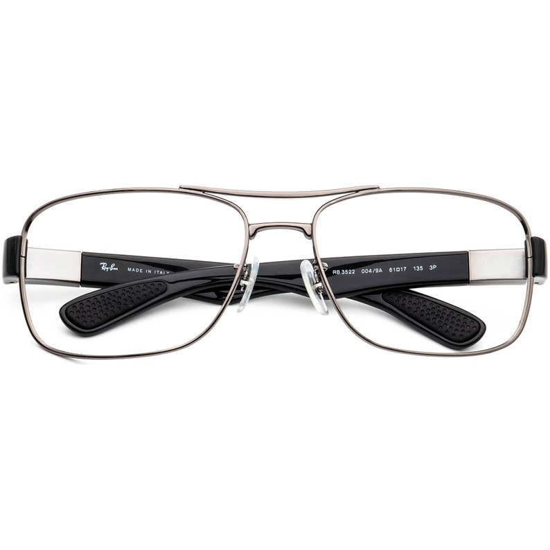 Puede incluir: Gafas de metal de color plateado con patillas negras y lentes transparentes. Las patillas est&aacute;n etiquetadas con "Ray-Ban MADE IN ITALY RB 3532 004/9A 51□17 135 3P".