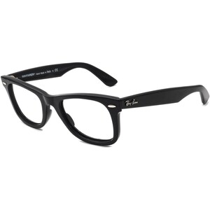 May include: Black plastic Wayfarer style spectacles with clear lenses. The glasses have a gold Ray-Ban logo on the right temple.