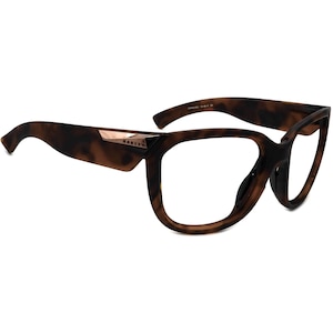 May include: Tortoise shell frame eyeglasses with a rose gold accent on the temple and the word "OAKLEY" printed on the side.