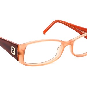 Può includere: Un paio di occhiali da vista color pesca con aste marroni e un logo "F" dorato sul lato.