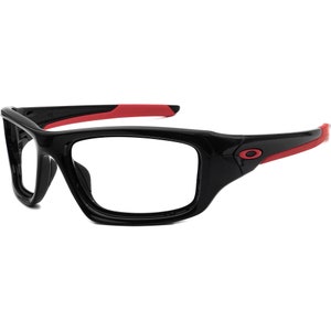 May include: Black and red sports glasses with a clear lens. The glasses have a thick frame and a red accent on the arms.