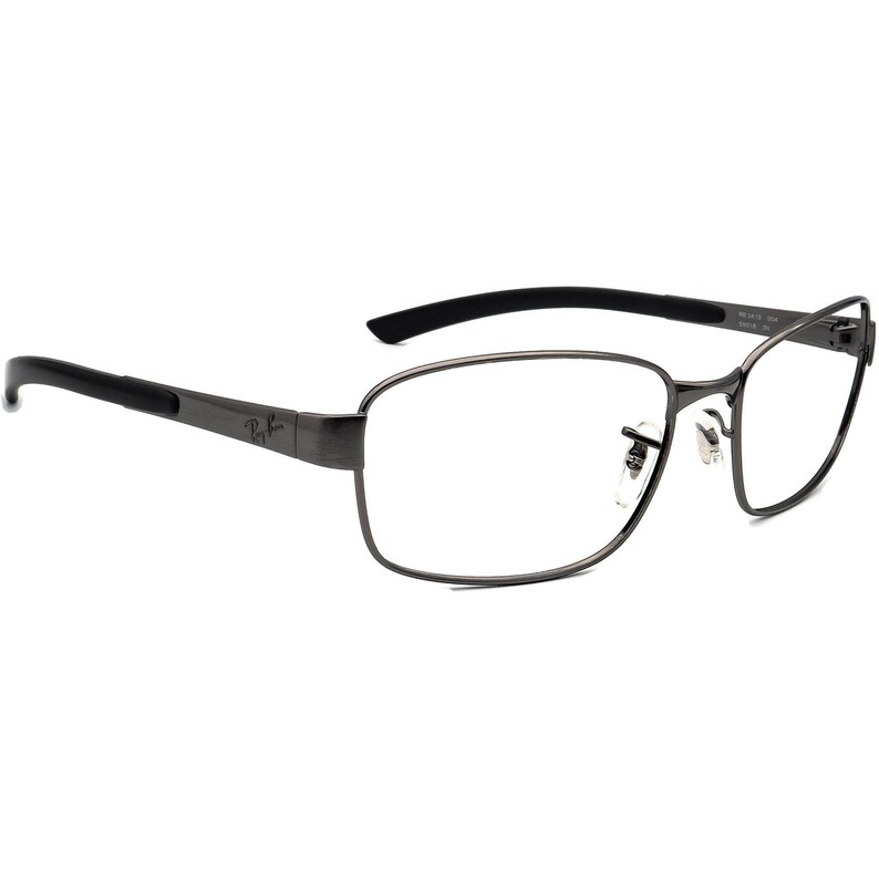 May include: Gunmetal Ray-Ban spectacles with rectangular lenses and black arms. The frames have a modern design, with the Ray-Ban logo on the temple. The spectacles are designed for vision correction.