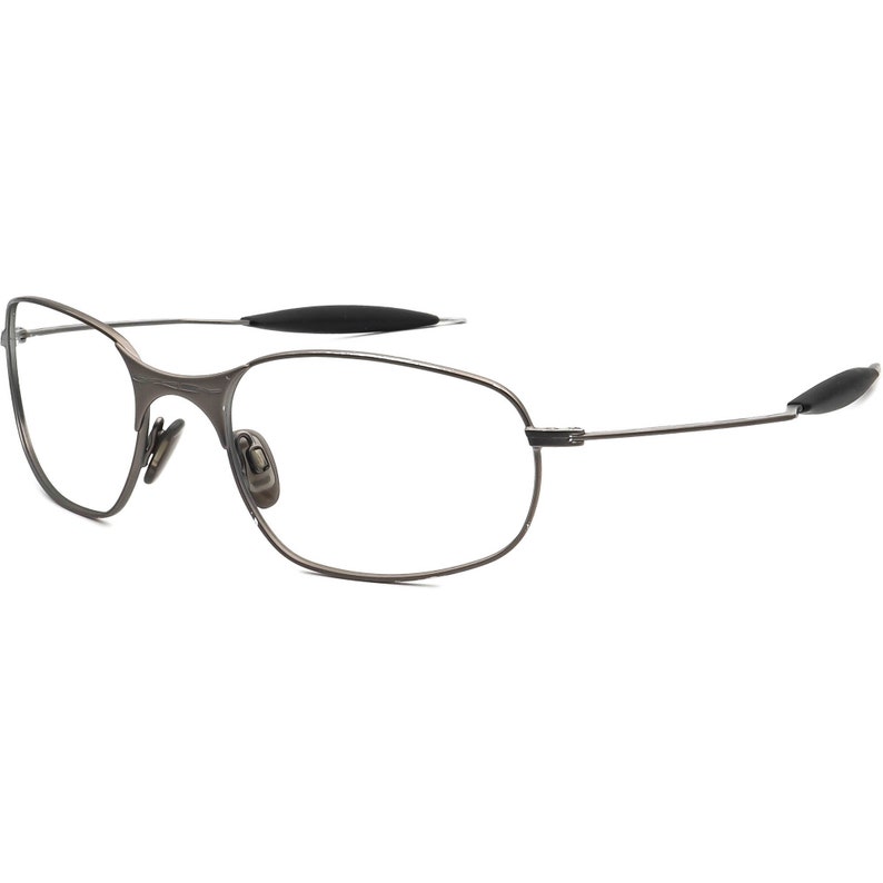 May include: A pair of rimless eyeglasses with a dark gray metal frame. The lenses are clear, and the temples have black rubberized tips for comfort. The design is sleek and modern, suitable for everyday wear.