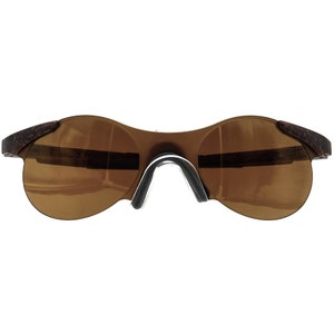 May include: Brown wraparound sunglasses with a dark brown lens.