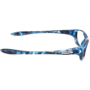May include: Blue and black Oakley sunglasses with a marbled pattern. The sunglasses have a silver Oakley logo on the side.