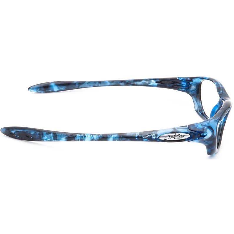 May include: Blue and black Oakley sunglasses with a marbled pattern. The sunglasses have a silver Oakley logo on the side.