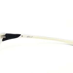 May include: White and black eyeglasses with the word "Scout" printed on the side.