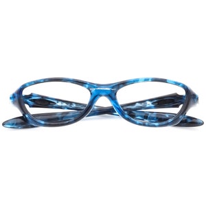 May include: Blue and black patterned eyeglasses with a silver Oakley logo on the frame.