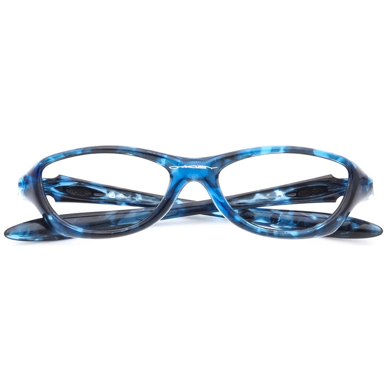 May include: Blue and black patterned eyeglasses with a silver Oakley logo on the frame.