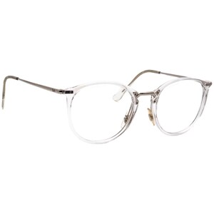 Peut inclure: Lunettes à monture ronde transparente avec des branches et un pont argentés. Les verres sont transparents et la monture est de couleur claire translucide. Les lunettes ont un design classique et minimaliste.