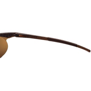 May include: A pair of brown sunglasses with a flexible frame and brown lenses.