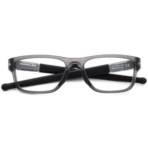 May include: Grey rectangular eyeglasses with black arms. The arms are labelled "MARSHAL MNP" and "144 OX8081-0233 Satin Grey Smoke CE China".