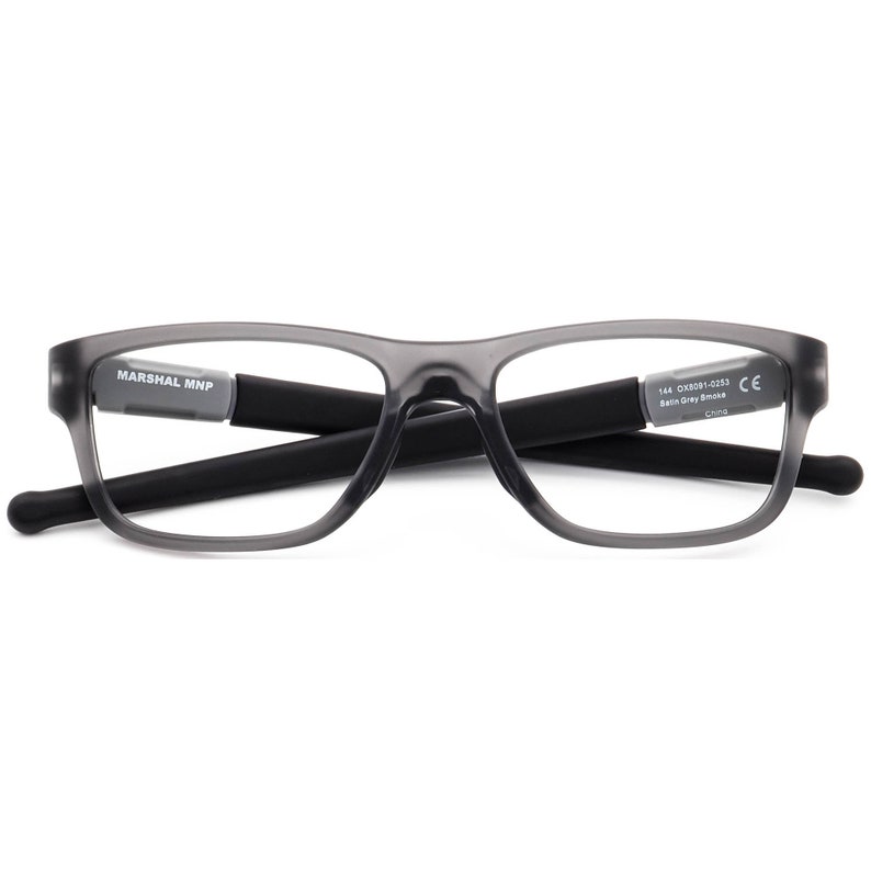 May include: Grey rectangular eyeglasses with black arms. The arms are labelled "MARSHAL MNP" and "144 OX8081-0233 Satin Grey Smoke CE China".