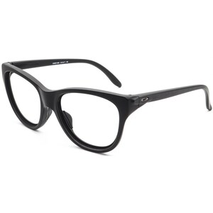 May include: Black eyeglasses with a rounded cat-eye shape. The frames are matte black with a subtle logo on the temples. The lenses are clear. The glasses are designed for vision correction.