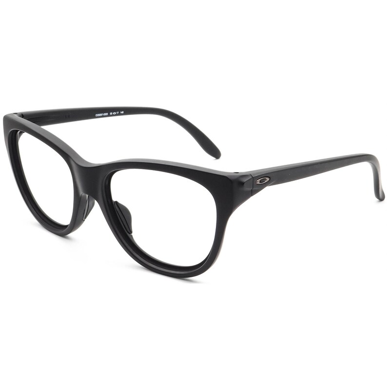 May include: Black eyeglasses with a rounded cat-eye shape. The frames are matte black with a subtle logo on the temples. The lenses are clear. The glasses are designed for vision correction.