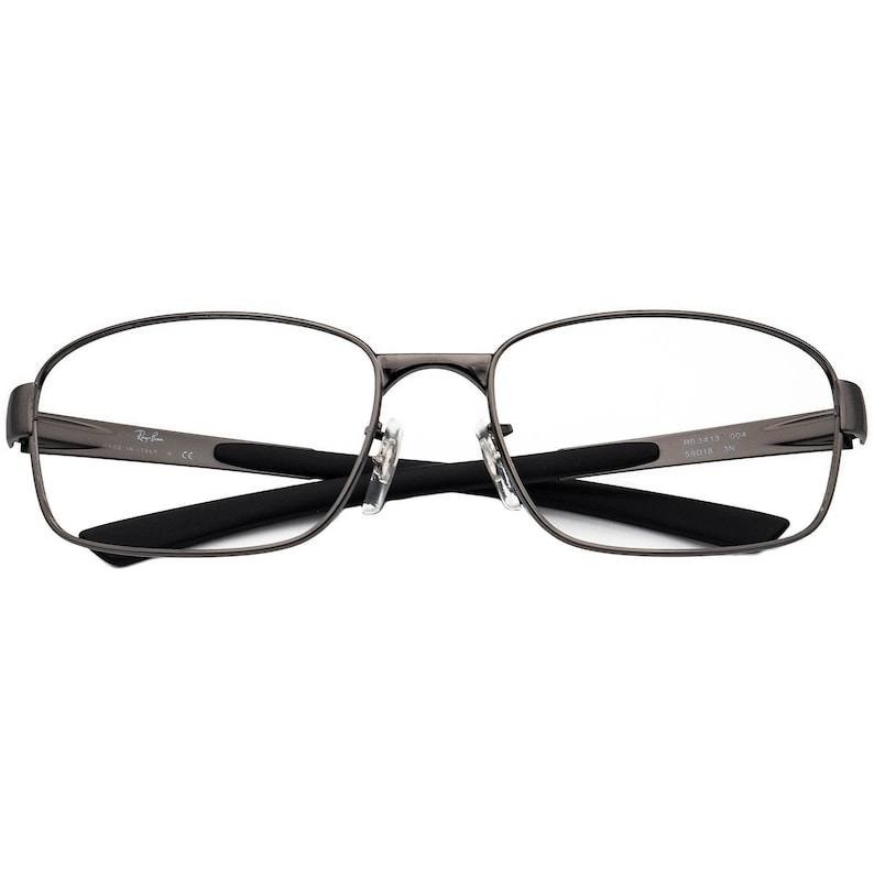 May include: Gunmetal Ray-Ban spectacles with a rectangular frame and clear lenses. The glasses have black temple arms and nose pads. The Ray-Ban logo is visible on the left temple. The model number is visible on the right temple.