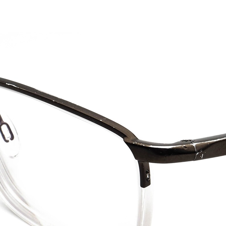 May include: A pair of black metal frame eyeglasses with clear lenses. The glasses have a simple, modern design.