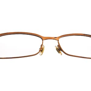 May include: A pair of brown metal eyeglasses with a rectangular frame.