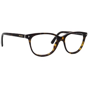 May include: Eyeglasses with a tortoiseshell pattern. The frames have a cat-eye shape and feature the brand name "PRADA" on the left arm. The lenses are clear, and the overall design is sleek and stylish.