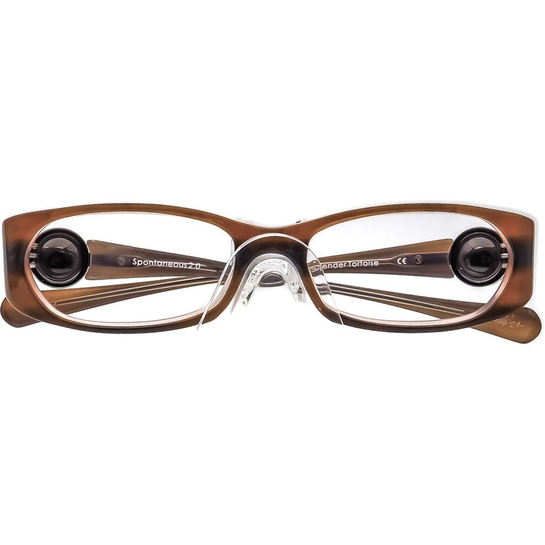 May include: Brown tortoiseshell eyeglasses with clear lenses and a clear nose bridge. The glasses have a black and silver detail on the arms and the text "Spontaneous 2.0" and "Wander Tortoise" on the arms.