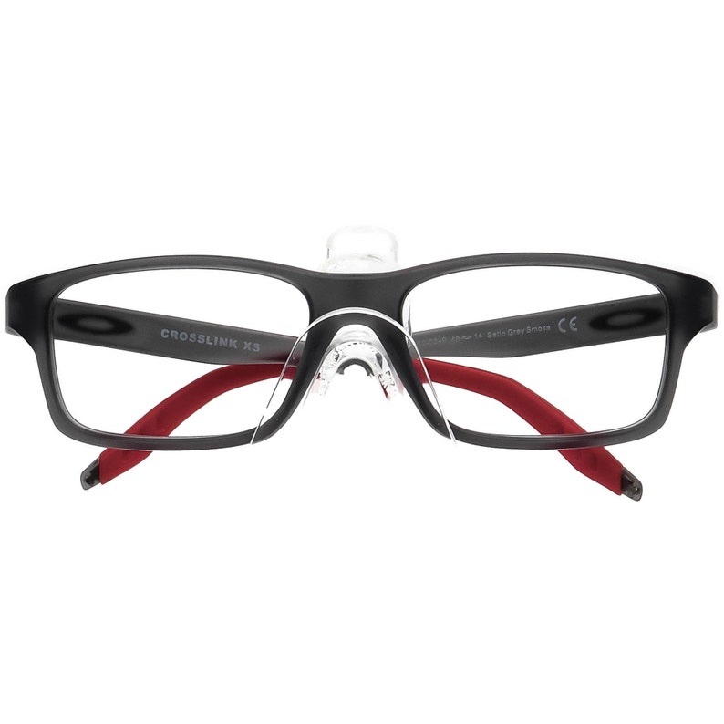 May include: Black rectangular eyeglasses with red arms and a clear nose bridge. The frame has the text "CROSSLINK XS" printed on the left lens.