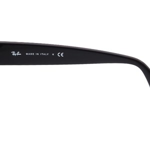May include: Black plastic sunglasses with a gold hinge and the text "Ray-Ban MADE IN ITALY K CE" on the side.
