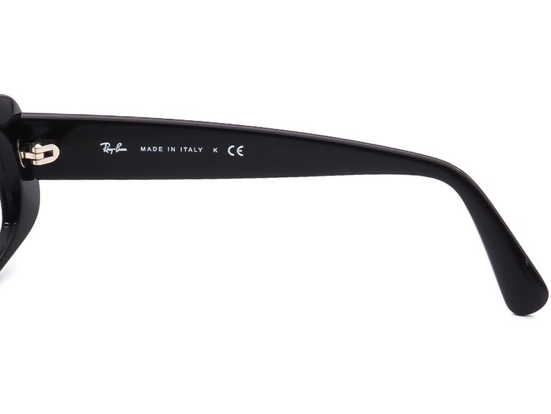 May include: Black plastic sunglasses with a gold hinge and the text "Ray-Ban MADE IN ITALY K CE" on the side.