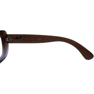 K&ouml;nnte beinhalten: Nahaufnahme der braunen Kunststoffb&uuml;gel einer Sonnenbrille. Die B&uuml;gel sind mit dem Text "MADE IN ITALY K CE" gekennzeichnet.