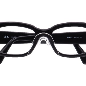 May include: Black plastic framed eyeglasses with clear lenses. The Ray-Ban logo and MADE IN ITALY are printed on the left arm. The right arm has the text RB 4122 601/71 3N.
