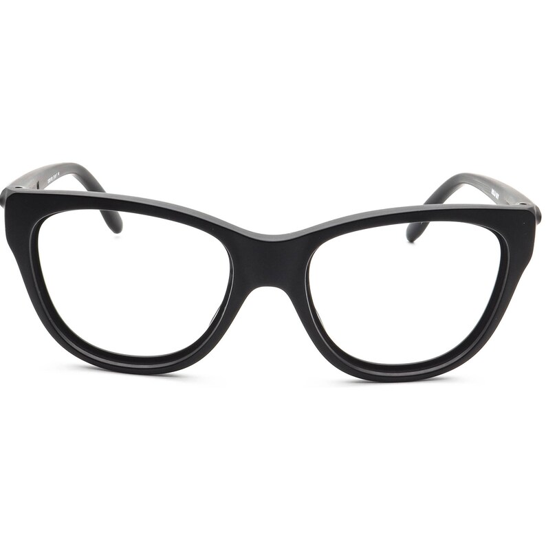 May include: Black cat-eye style eyeglasses with a thick frame. The glasses have a classic, retro design with a bold, angular shape. The lenses are clear, and the frame is a solid, matte black.