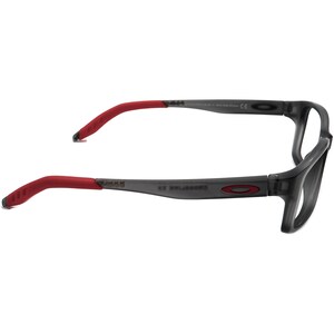 May include: Gray and red rectangular frame eyeglasses with a gray lens. The frame has a subtle curve and the arms have a red rubber coating.