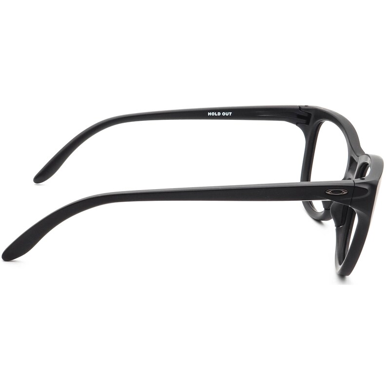 May include: Black eyeglasses with a thick frame. The glasses have a rectangular shape and curved temples. The text "HOLD OUT" is printed on the left temple. The Oakley logo is visible on the right side of the frame.