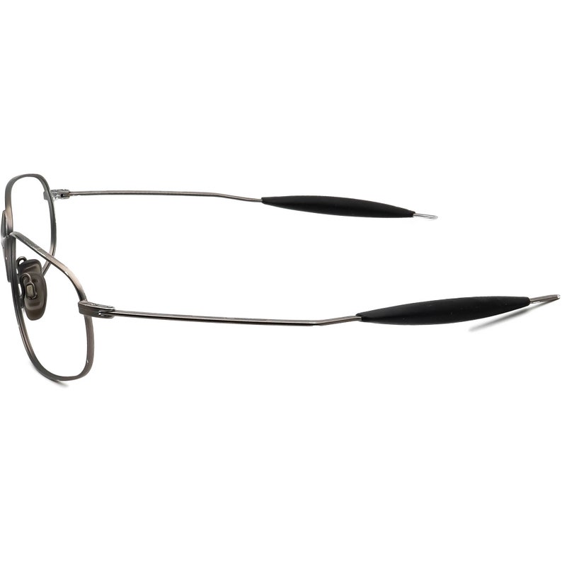 May include: A pair of eyeglasses with a thin, gunmetal-colored metal frame. The lenses are clear, and the temples have black rubberized grips. The glasses are designed with a classic, aviator-style shape.