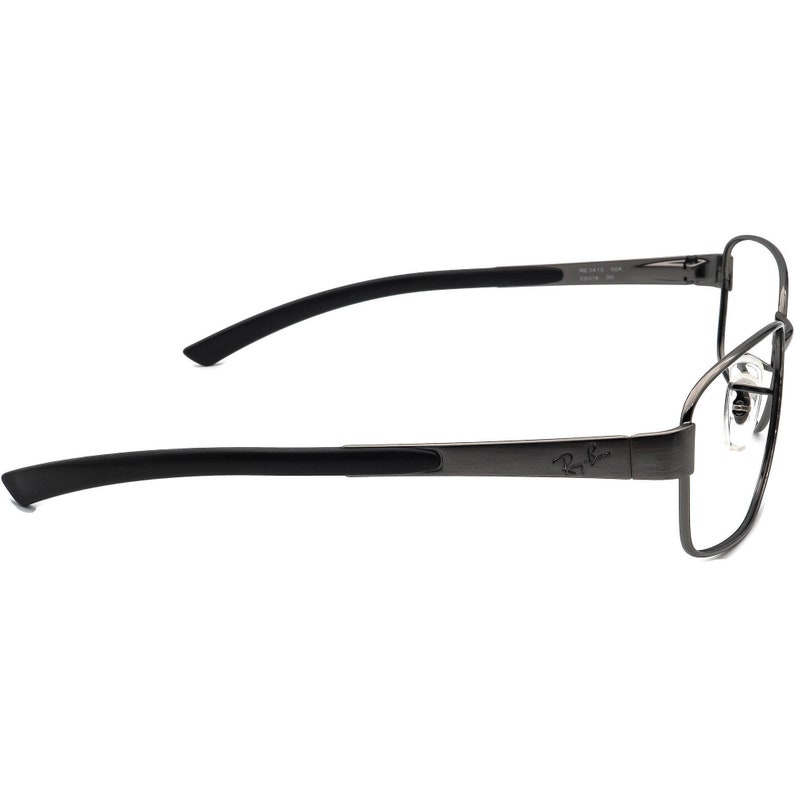 May include: Ray-Ban eyeglasses with a dark grey metal frame and black temples. The glasses have a rectangular lens shape and the Ray-Ban logo is visible on the temple. The design is sleek and modern.